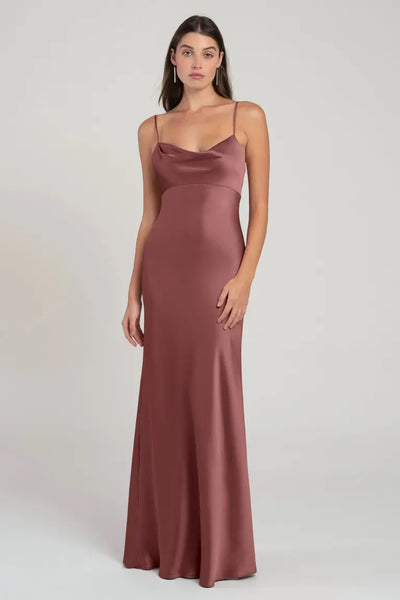 A woman wearing a long, satin, dusky pink bridesmaid dress with spaghetti straps. 
Product Name: Addison - Bridesmaid Dress by Jenny Yoo
Brand Name: Bergamot Bridal