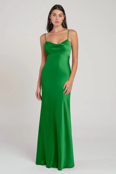 Woman posing in a green satin Addison bridesmaid dress by Jenny Yoo with an empire waist from Bergamot Bridal.