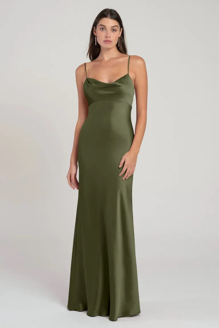 Woman posing in an Addison - Bridesmaid Dress by Jenny Yoo in olive green satin with spaghetti straps and an empire waist from Bergamot Bridal.