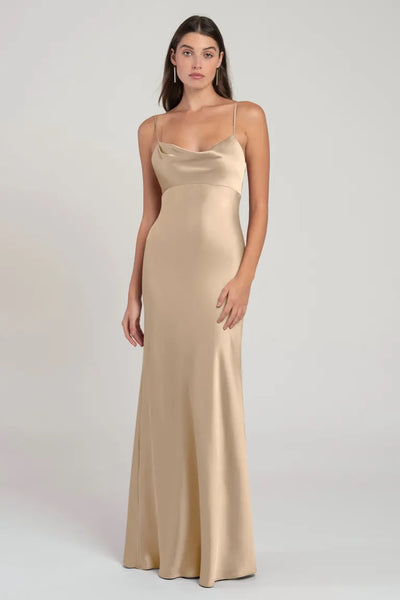 Woman posing in a simple, elegant beige satin slip evening gown. 
Revised: Woman posing in an Addison - Bridesmaid Dress by Jenny Yoo from Bergamot Bridal.