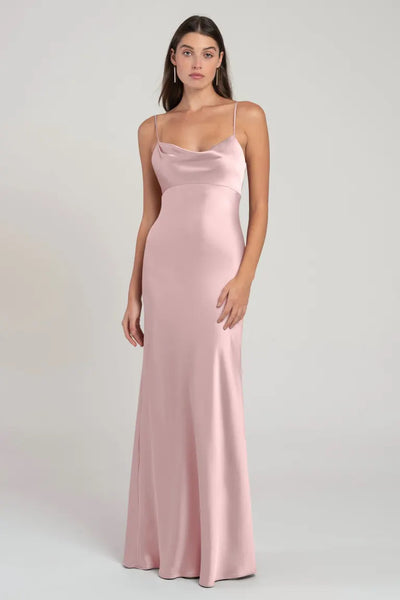 Woman modeling a long, pink satin Addison bridesmaid dress by Jenny Yoo with spaghetti straps and an empire waist at Bergamot Bridal.