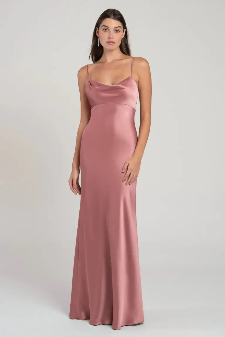 A woman in a sleek, bias cut, pink satin Addison bridesmaid dress by Jenny Yoo from Bergamot Bridal.