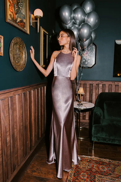 Woman in an Alessia bridesmaid dress by Jenny Yoo, holding balloons, stands poised in an elegant room.