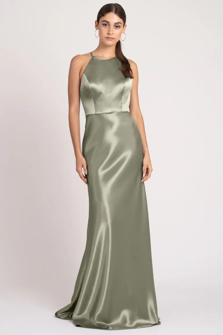 A woman in an elegant satin olive green Alessia bridesmaid dress by Jenny Yoo at Bergamot Bridal.