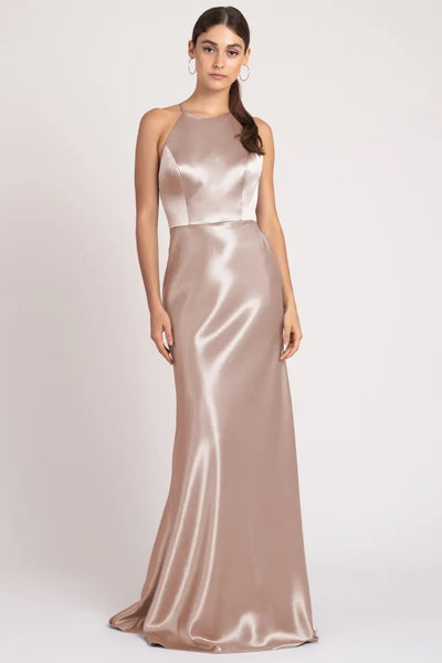 Woman posing in an elegant Alessia bridesmaid dress by Jenny Yoo with a high neckline from Bergamot Bridal.