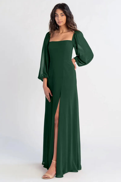 Woman modeling an Althea - Bridesmaid Dress by Jenny Yoo chiffon green evening gown with a thigh-high slit from Bergamot Bridal.