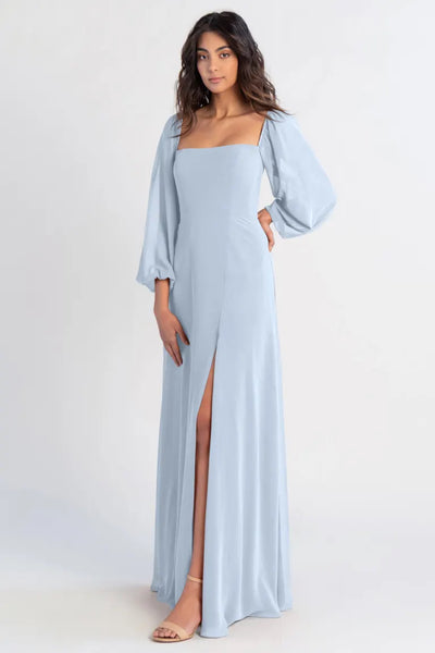 Woman in a light blue chiffon evening gown with a high slit and off-the-shoulder sleeves, the Althea - Bridesmaid Dress by Jenny Yoo from Bergamot Bridal.
