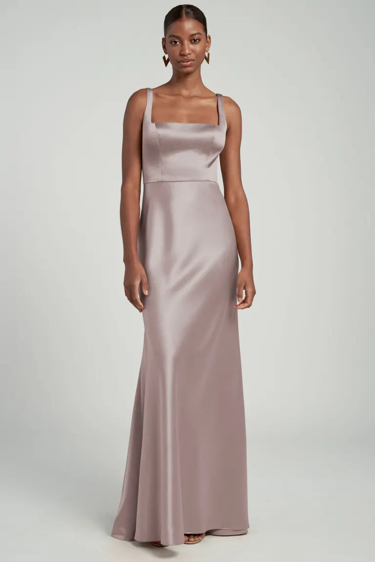 Woman posing in an elegant mauve Ariana bridesmaid dress by Jenny Yoo with wide-set straps from Bergamot Bridal.