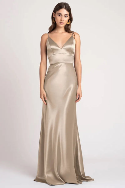 Woman in an elegant champagne Brenna bridesmaid dress by Jenny Yoo, made from satin back crepe fabric at Bergamot Bridal.