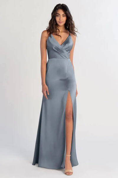 Woman in an elegant gray satin Beckette bridesmaid dress by Jenny Yoo with a thigh-high slit and V-neck from Bergamot Bridal.