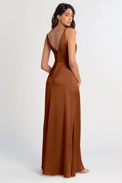 Woman posing in an elegant backless brown satin Beckette bridesmaid dress by Jenny Yoo with a simplistic design from Bergamot Bridal.