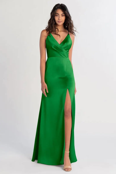 Woman in a Beckette - Bridesmaid Dress by Jenny Yoo in green satin with a thigh-high slit from Bergamot Bridal.