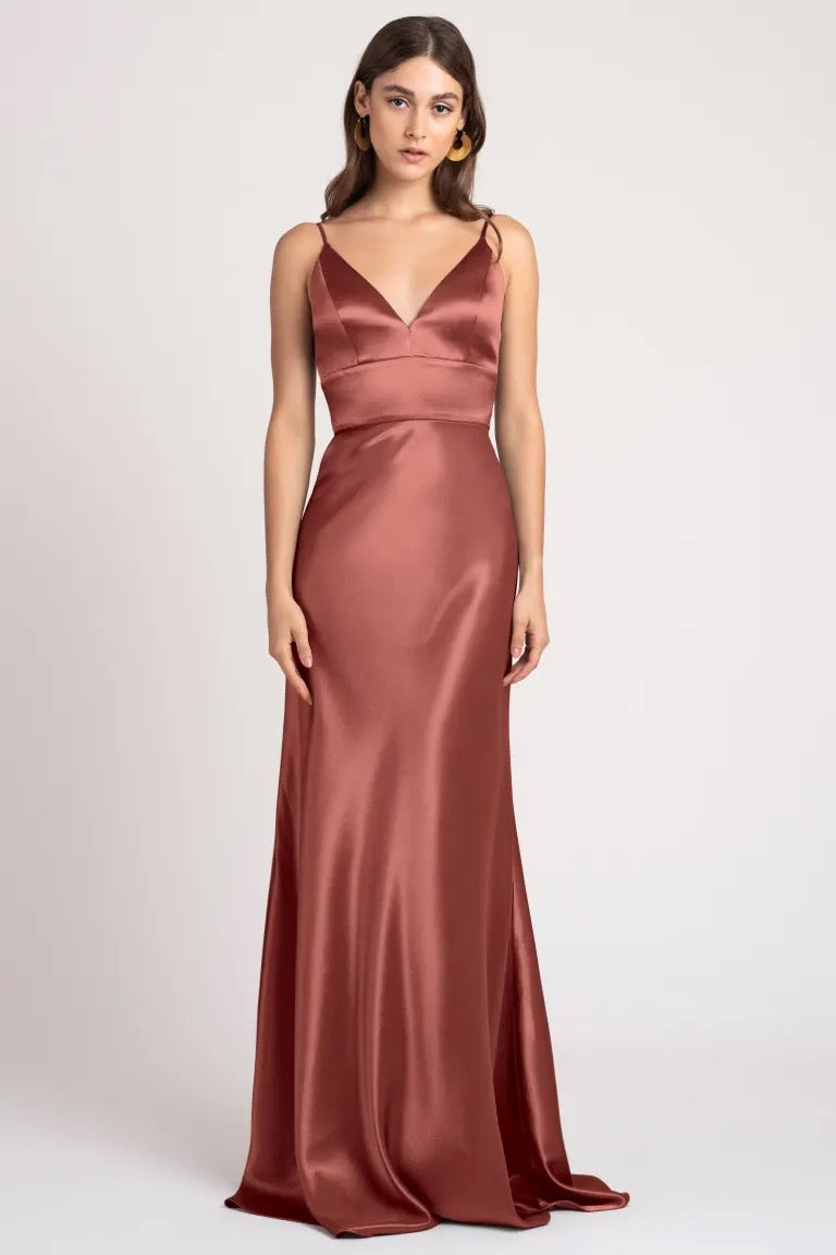 Woman in a long Brenna - Bridesmaid Dress by Jenny Yoo made of satin back crepe fabric from Bergamot Bridal.