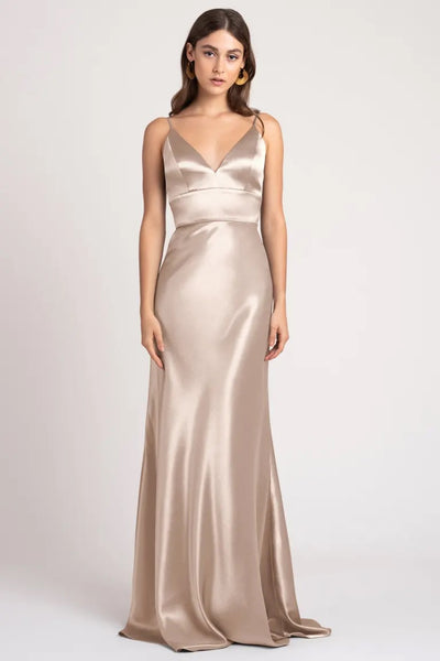 Woman posing in a sleek Brenna - Bridesmaid Dress by Jenny Yoo made of satin back crepe fabric, with a subtle train from Bergamot Bridal.