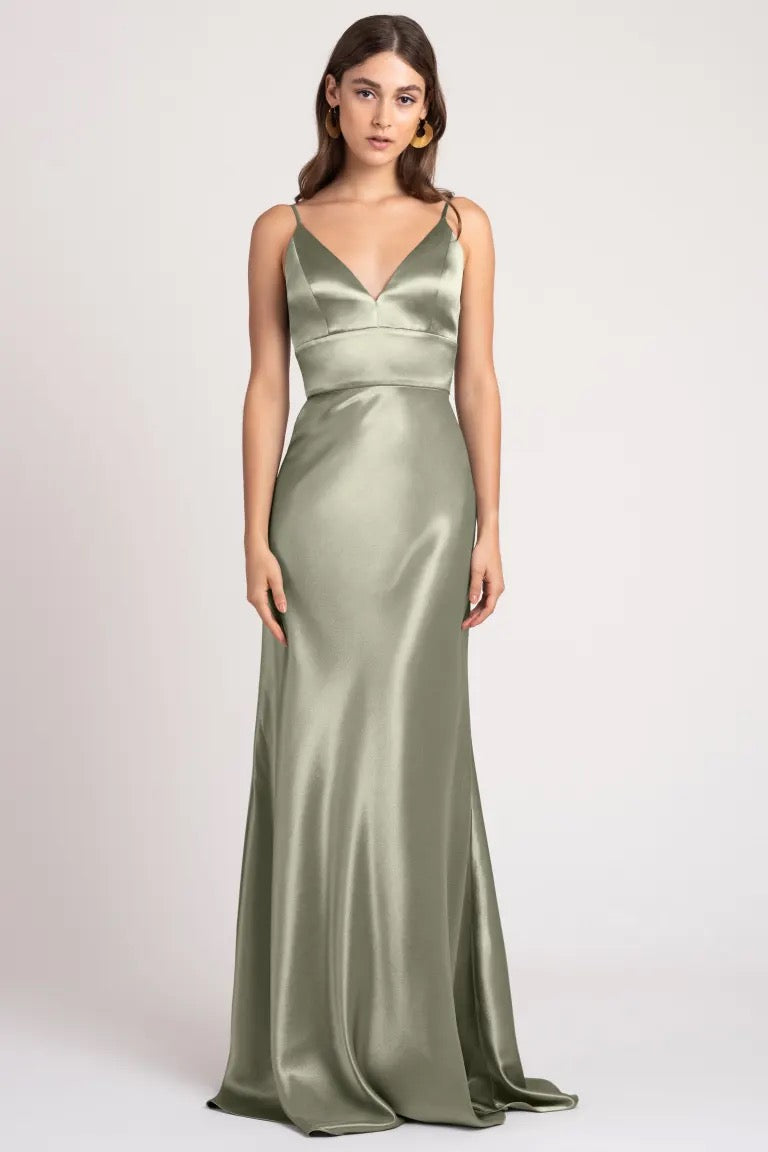 Woman modeling an elegant sage green satin back crepe evening gown with spaghetti straps, perfect as a Brenna - Bridesmaid Dress by Jenny Yoo from Bergamot Bridal.