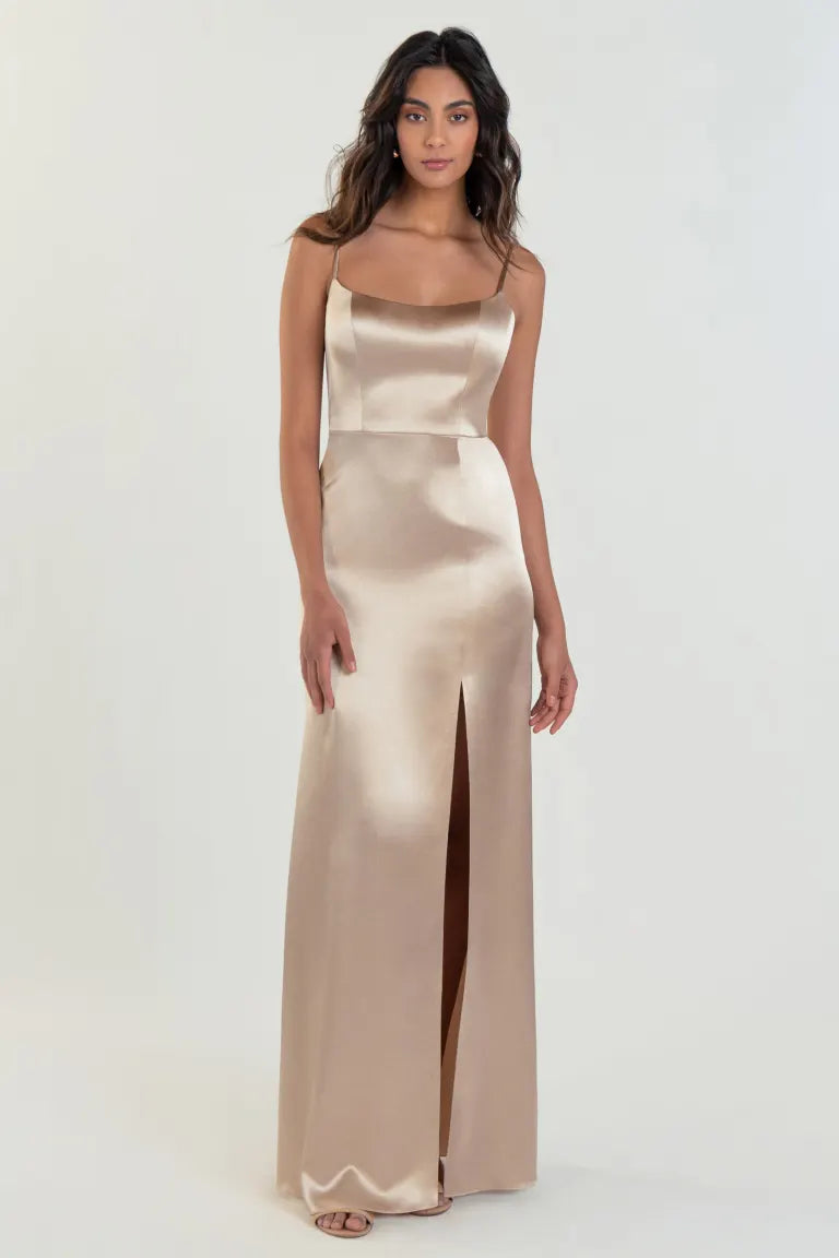 A woman wearing an elegant Chase - Bridesmaid Dress by Jenny Yoo from Bergamot Bridal with a scoop neck and a slit.