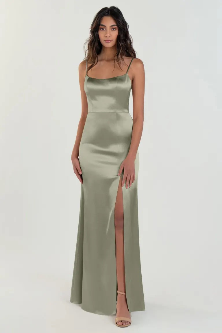 Woman in an elegant olive green satin back crepe Chase bridesmaid dress by Jenny Yoo with a thigh-high slit from Bergamot Bridal.