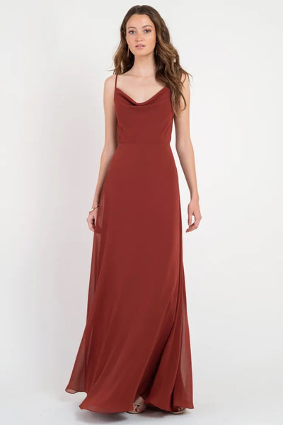 Woman in an elegant Colby - Jenny Yoo Bridesmaid Dress by Bergamot Bridal with a cowl neckline poses against a plain background.