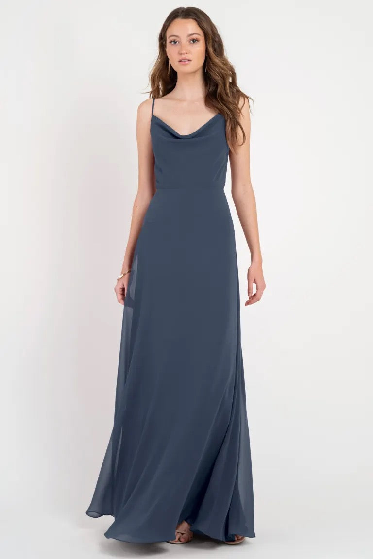 Woman posing in an elegant navy blue slip Colby - Jenny Yoo Bridesmaid Dress with a cowl neckline from Bergamot Bridal.