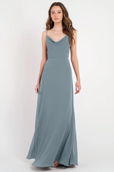 Woman in a flowing grey Colby - Jenny Yoo bridesmaid dress with a cowl neckline from Bergamot Bridal.