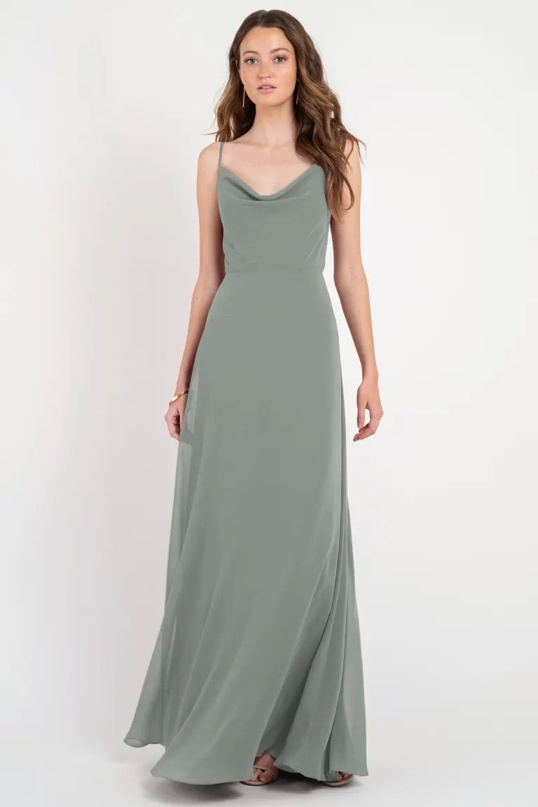 Woman posing in an elegant sage green Colby - Jenny Yoo Bridesmaid Dress with a cowl neckline from Bergamot Bridal.