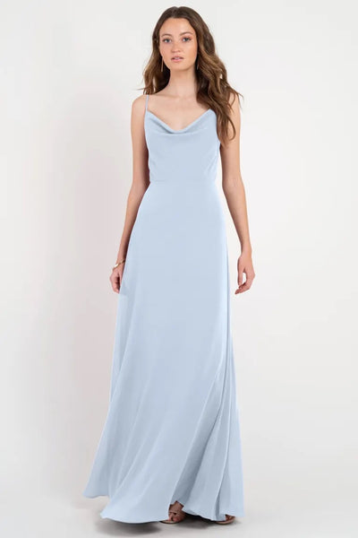 A woman standing and posing in a light blue, sleeveless, floor-length slip dress from Bergamot Bridal - Colby by Jenny Yoo Bridesmaid Dress.