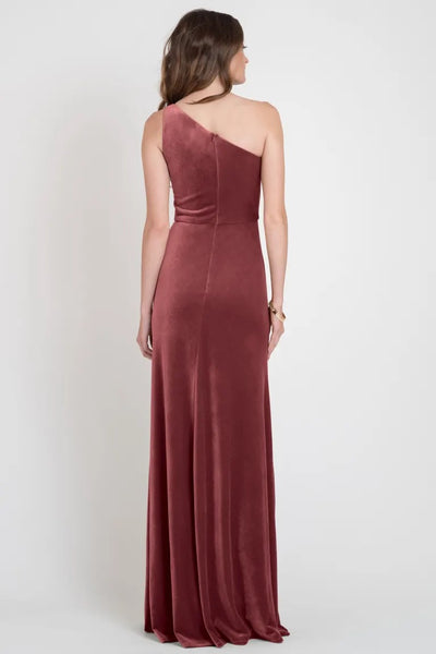 Woman in an elegant one-shoulder stretch velvet gown, Cybill - Bridesmaid Dress by Jenny Yoo, photographed from the back. Designed by Bergamot Bridal.
