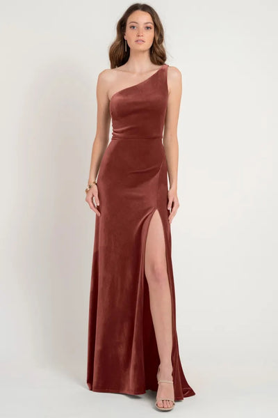 Woman in an elegant one-shoulder Cybill - Bridesmaid Dress by Jenny Yoo gown with a thigh-high slit, store sample size 12 from Bergamot Bridal.