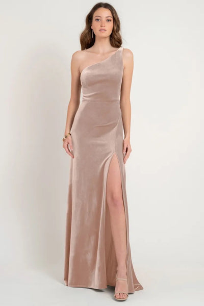 Woman posing in an elegant Cybill - Bridesmaid Dress by Jenny Yoo evening gown with a thigh-high slit in beige from Bergamot Bridal.