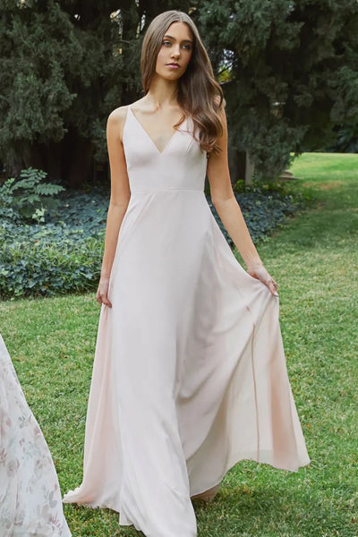 A woman in a Dani - Bridesmaid Dress by Jenny Yoo with a keyhole back standing in a garden setting from Bergamot Bridal.