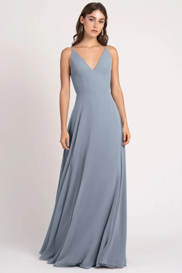 A woman in a Dani - Bridesmaid Dress by Jenny Yoo, a Bergamot Bridal brand, stands against a neutral background.
