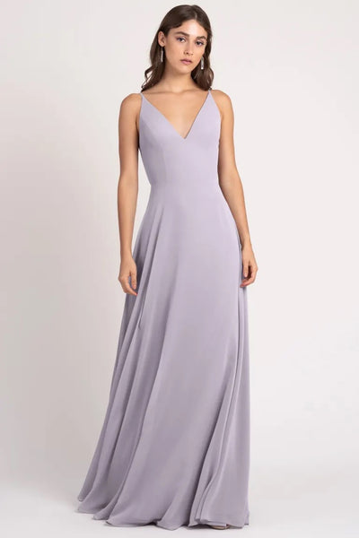 Woman posing in a simple, elegant lavender evening gown with a keyhole back, the Dani Bridesmaid Dress by Jenny Yoo from Bergamot Bridal.