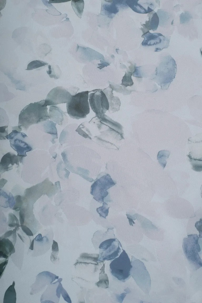 Abstract blue and gray watercolor brushstrokes on a light background, reminiscent of the pattern on a Salma printed chiffon dress by Jenny Yoo Bridesmaid Dress at Bergamot Bridal.