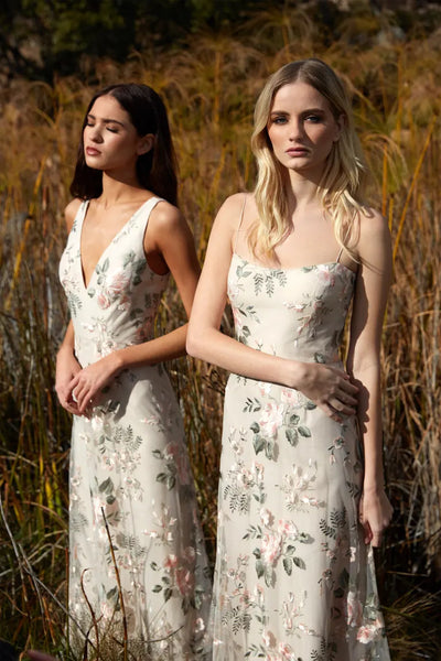 Two women in Drew - Jenny Yoo Bridedmaid Dresses from Bergamot Bridal standing in a field with tall grasses.