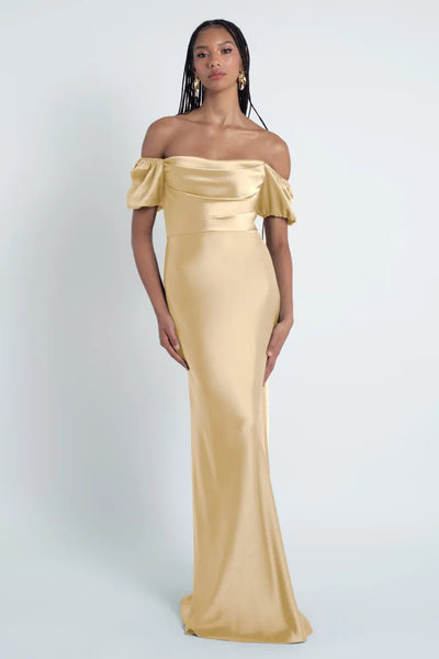 Woman in an elegant off-the-shoulder champagne-colored Jenny Yoo Bridesmaid Dress with puff sleeves from Bergamot Bridal.