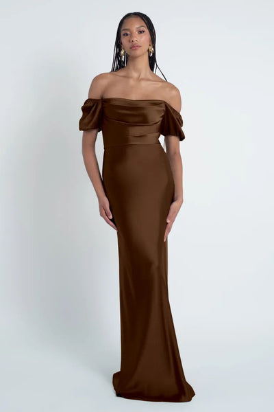 Woman in an elegant brown off-the-shoulder Jenny Yoo Bridesmaid Dress crafted from luxe satin fabric at Bergamot Bridal.