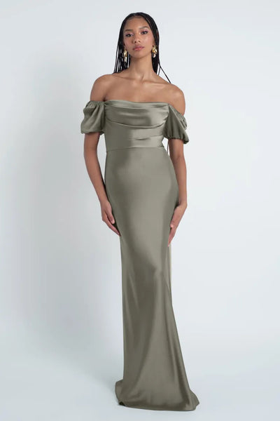 Woman in an elegant Jenny Yoo Bridesmaid Dress, crafted from luxe satin fabric, featuring a bias cut skirt and an off-the-shoulder silhouette standing against a white background.