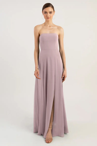 Woman in a strapless lilac Essie bridesmaid dress by Jenny Yoo with a front slit and an A-line skirt from Bergamot Bridal.