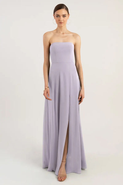 Woman in an Essie bridesmaid dress by Jenny Yoo in lilac with an A-line skirt and a thigh-high slit from Bergamot Bridal.