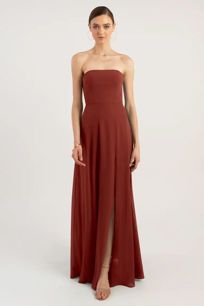 A woman in an elegant Essie - Bridesmaid Dress by Jenny Yoo from Bergamot Bridal with a slit.