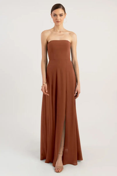 Woman in a sleek, strapless brown Essie - Bridesmaid Dress by Jenny Yoo gown with a slit from Bergamot Bridal.