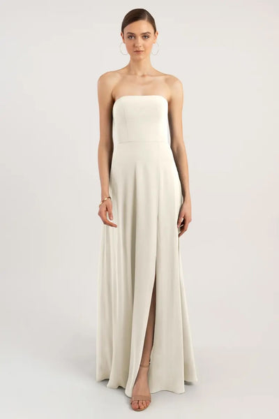 Woman in a strapless white Essie - Bridesmaid Dress by Jenny Yoo with a front slit from Bergamot Bridal.