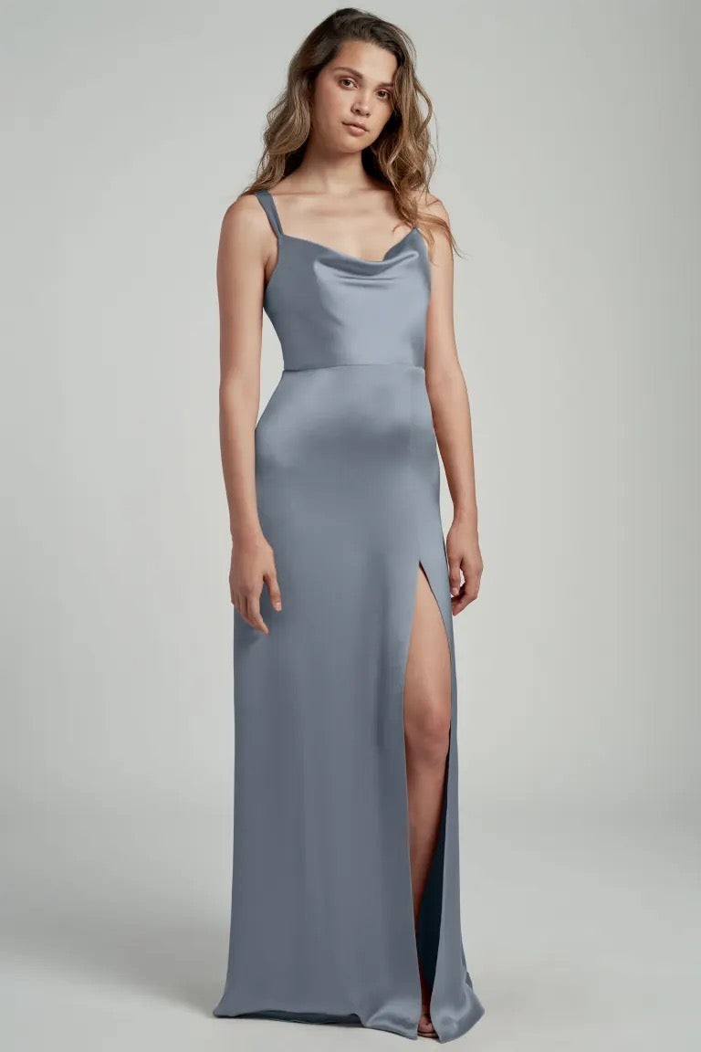Woman in a grey satin evening gown with a slit and a cowl neckline.
Product Name: Gina - Bridesmaid Dress by Jenny Yoo
Brand Name: Bergamot Bridal