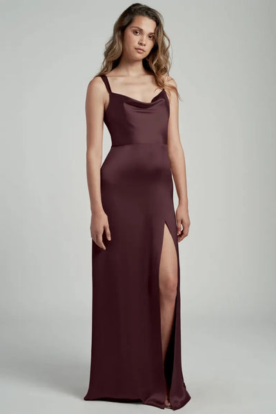 Woman in a Gina bridesmaid dress by Jenny Yoo in maroon satin with a thigh-high slit from Bergamot Bridal.