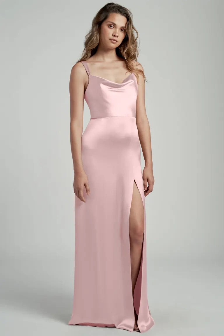 Woman in a pink satin Gina bridesmaid dress by Jenny Yoo with a thigh-high slit and cowl neckline from Bergamot Bridal.