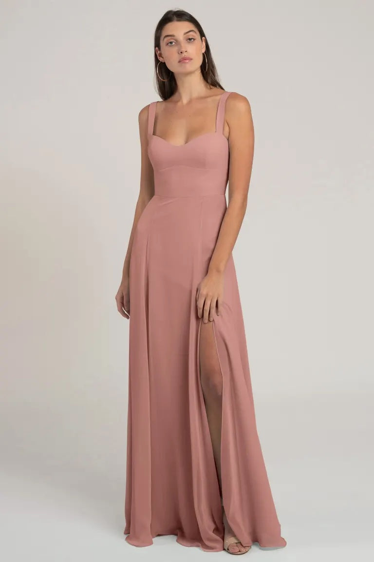 Woman posing in a long, elegant Harris Bridesmaid Dress by Jenny Yoo from Bergamot Bridal with a thigh-high slit and sweetheart neckline.