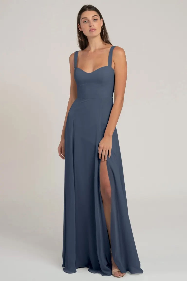 Woman posing in a flattering silhouette, Harris chiffon bridesmaid dress by Jenny Yoo with a bombshell neckline and a thigh-high slit from Bergamot Bridal.