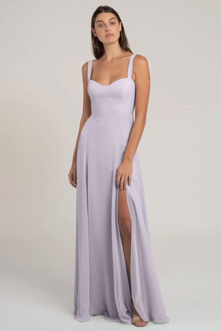 Woman posing in a lilac chiffon Harris bridesmaid dress by Jenny Yoo with a thigh-high slit from Bergamot Bridal.