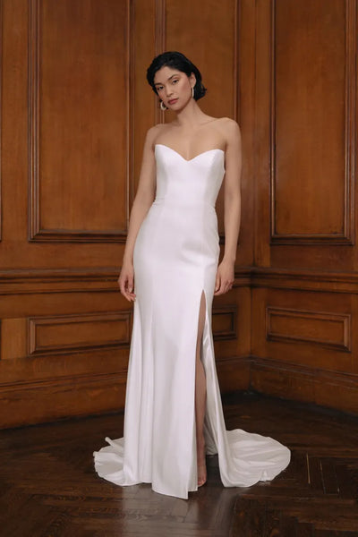 Woman posing in an elegant Jenny Yoo Wedding Dress gown featuring a sweetheart neckline and a thigh-high slit from Bergamot Bridal.