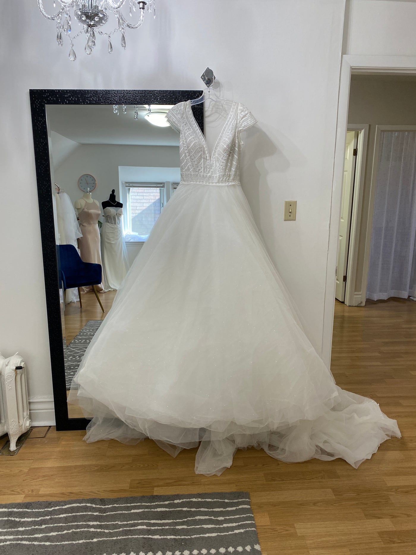 A Allure Disney Wedding Dress - Rapunzel - Off The Rack with a lace bodice on a mannequin reflected in a full-length mirror in Bergamot Bridal.